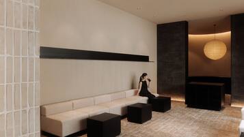A modern interior with a sofa, black ottomans, and a hanging light fixture.