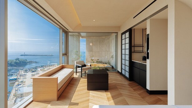 Ein modernes Apartment mit großem Balkon, einer Küche und Meerblick.