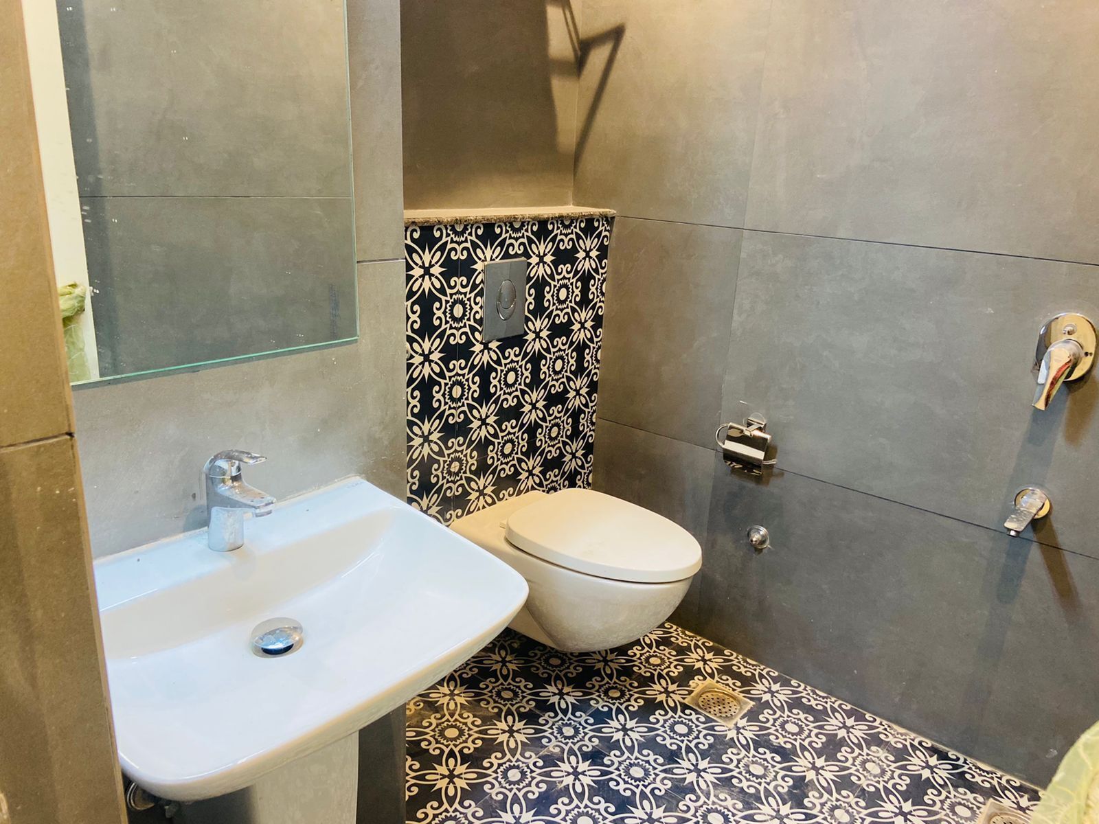 A small bathroom with a white sink, a toilet, and a shower.