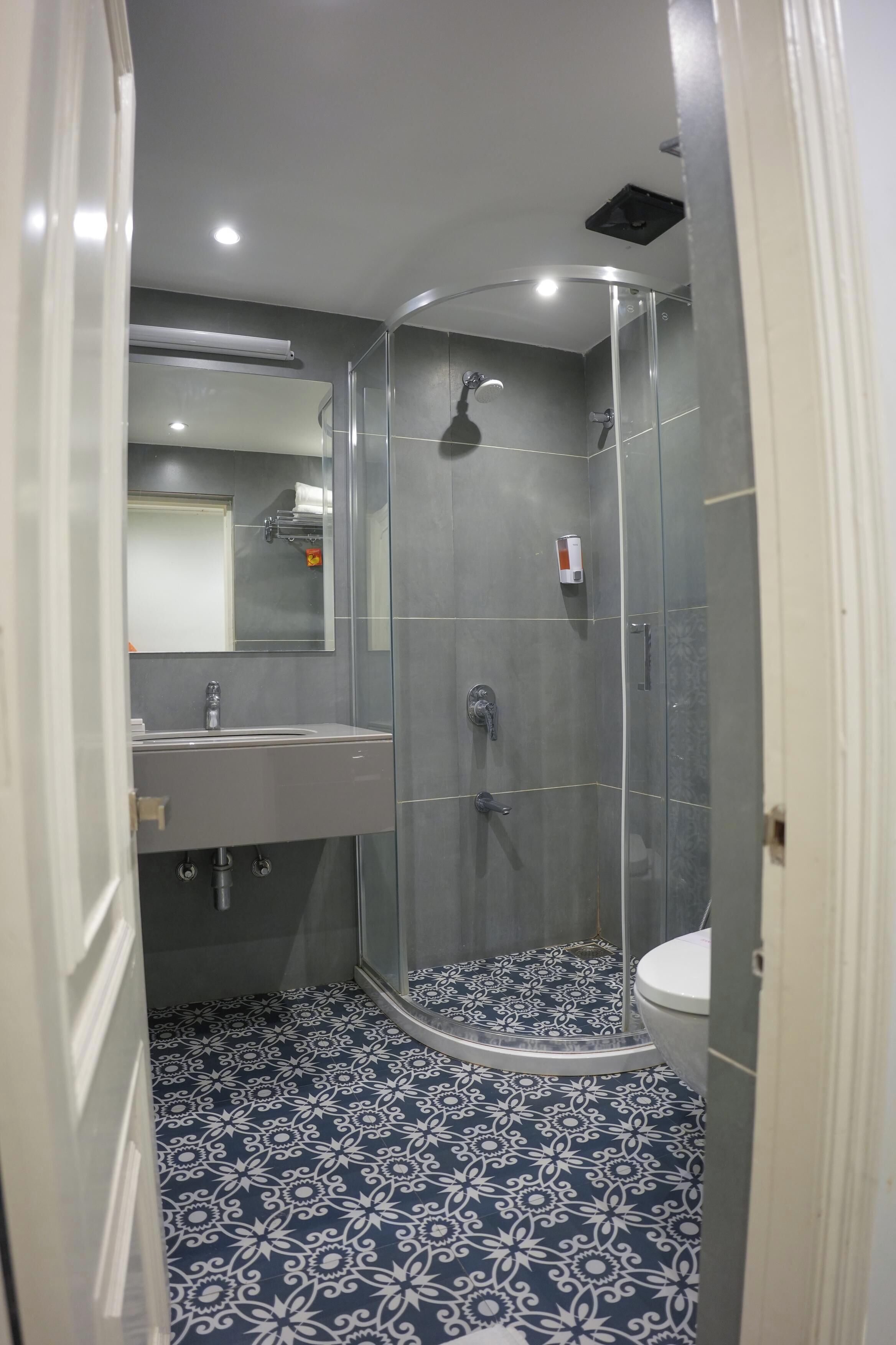 Une salle de bain moderne avec une douche à parois de verre, un lavabo et des toilettes.