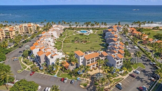 A resort with multiple buildings, a central pool, and a view of the ocean. - 20 yards from the beach • Private rooftop villa in exclusive neighborhood (Humacao)