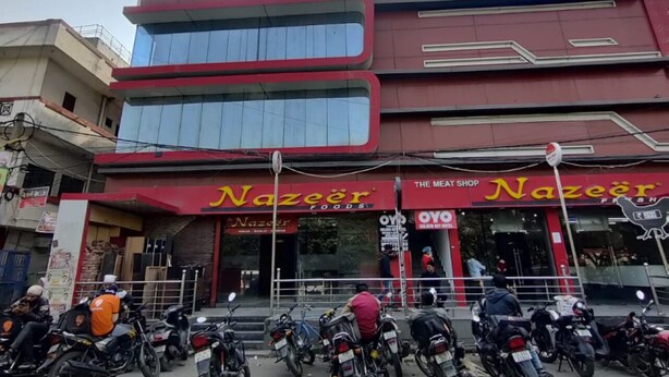 Ein Gebäude mit einem Schild für 'Oyo Townhouse' und 'Nazeer Foods' im Erdgeschoss.