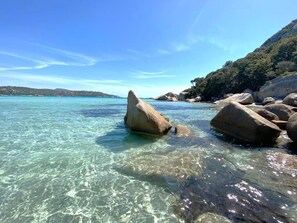 A clear coastal area with large rocks in shallow water, surrounded by hills. - Charmant 2 Pièces, Plage à Pied (Lecci)
