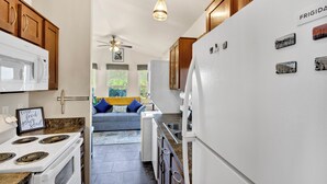 A kitchen with wooden cabinets, a white refrigerator, and a stove. - Saguaro Sunset Oasis (Tucson)