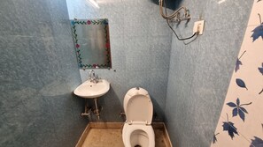 Een kleine badkamer met toilet, wastafel en douche.