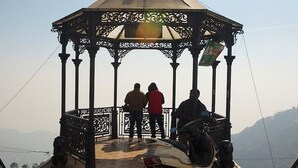 A gazebo with two people standing at the entrance, overlooking a mountainous landscape. - Hotel Apsara By Royal Collection Hotels (Dehradun)