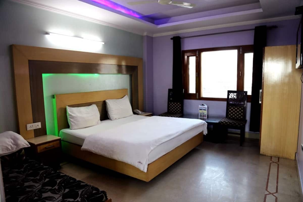 A bedroom with a bed, bedside table, and a window.