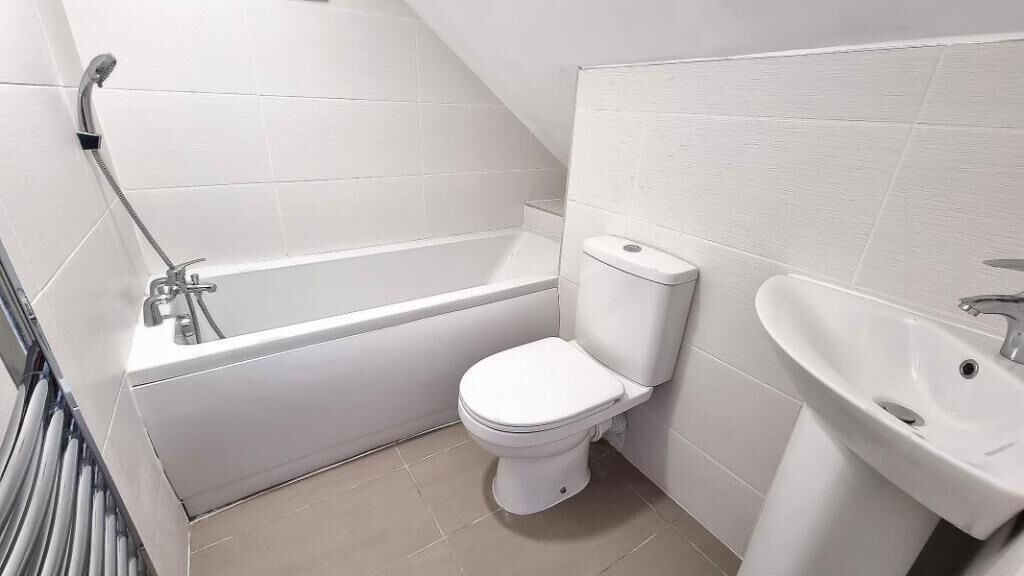 A bathroom with a bathtub, toilet, and sink.