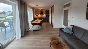 Un apartamento moderno con comedor, sofá y balcón.