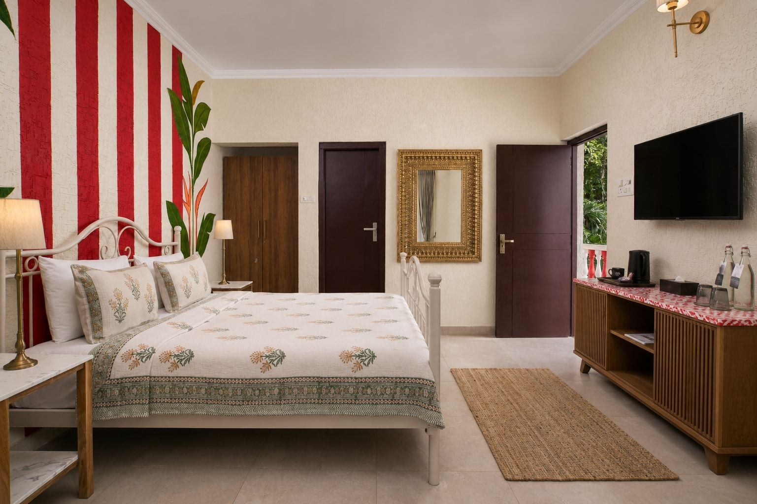 Une chambre d’hôtel comprenant un lit, des tables de chevet, une télévision, un miroir et une armoire.