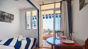 Une chambre avec un lit, une table à manger et une vue sur l’extérieur.