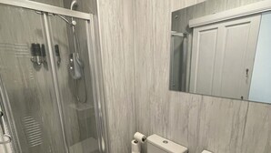 A bathroom with a glass-enclosed shower, a toilet, a sink, and a mirror above the sink. - Crown àros beag, ultra central, 2-bedroom, 2nd floor apartment.

 (Inverness)