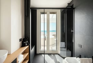 Enjoy a refreshing shower in the bathroom, which features a glass-enclosed shower area and a convenient sink.
