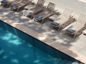 Relax by the pool with comfortable sun loungers and amenities at your fingertips.