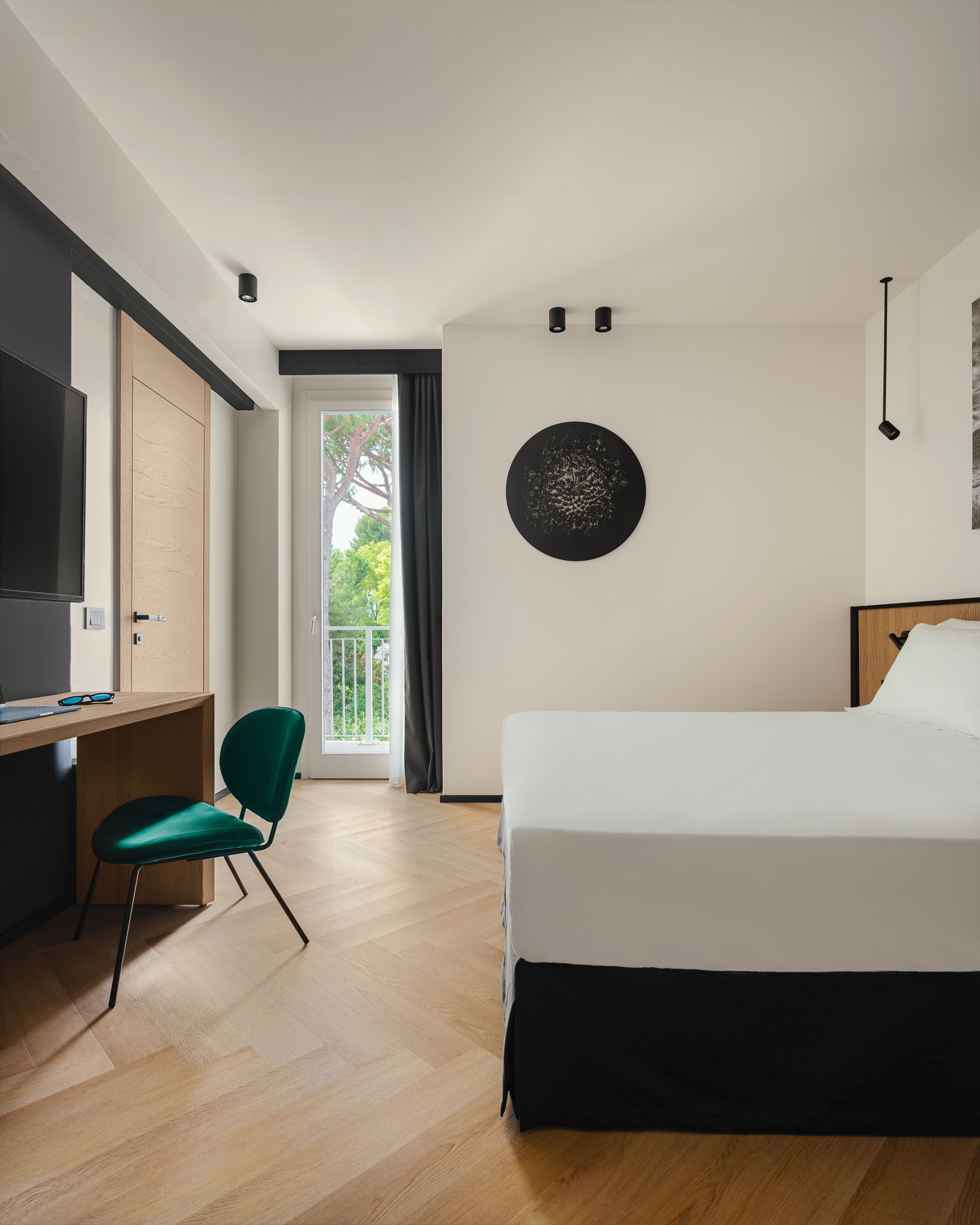 A modern hotel room with a bed, desk, and chair.