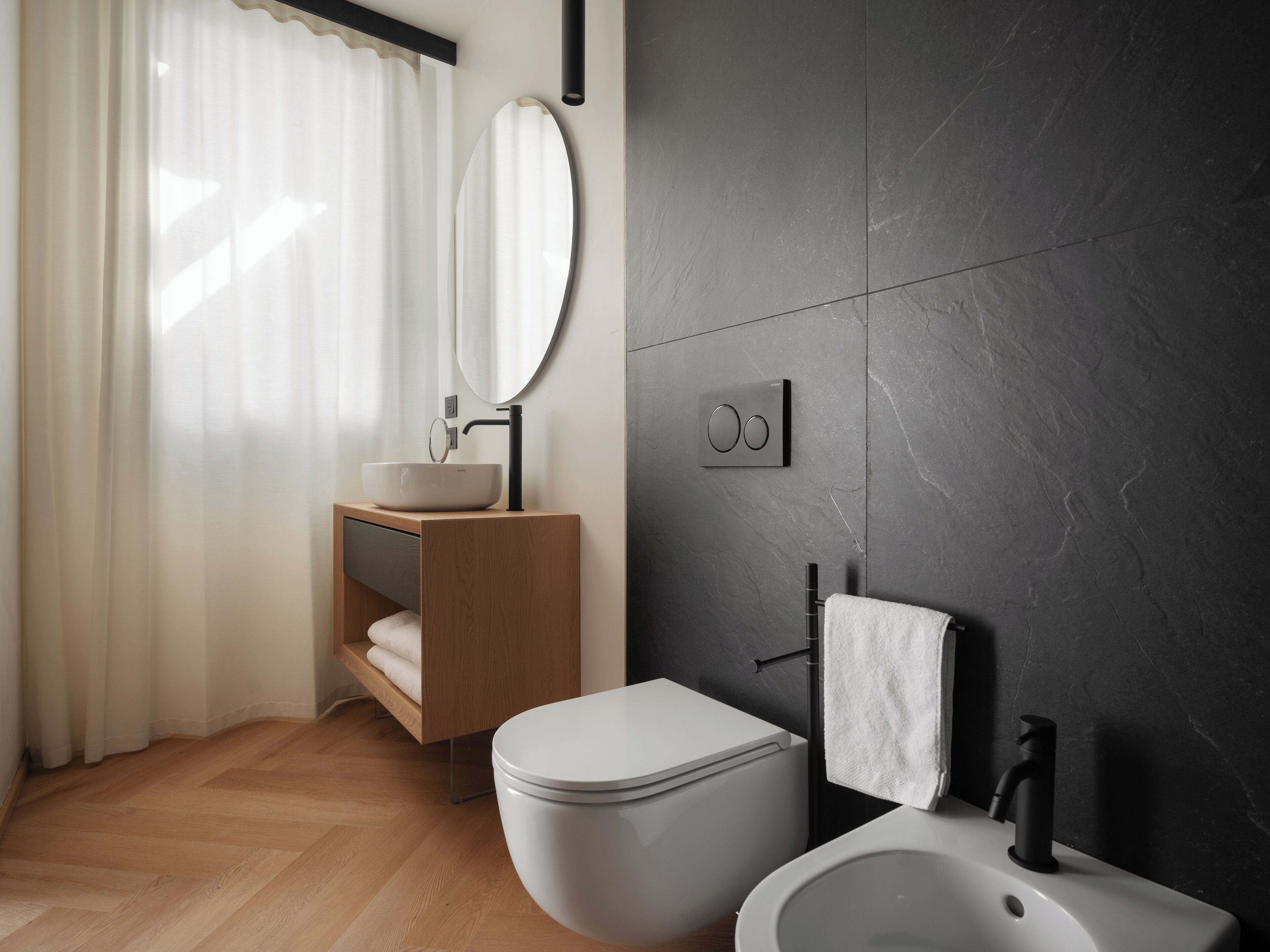 Un baño moderno con inodoro, bidé y lavamanos.