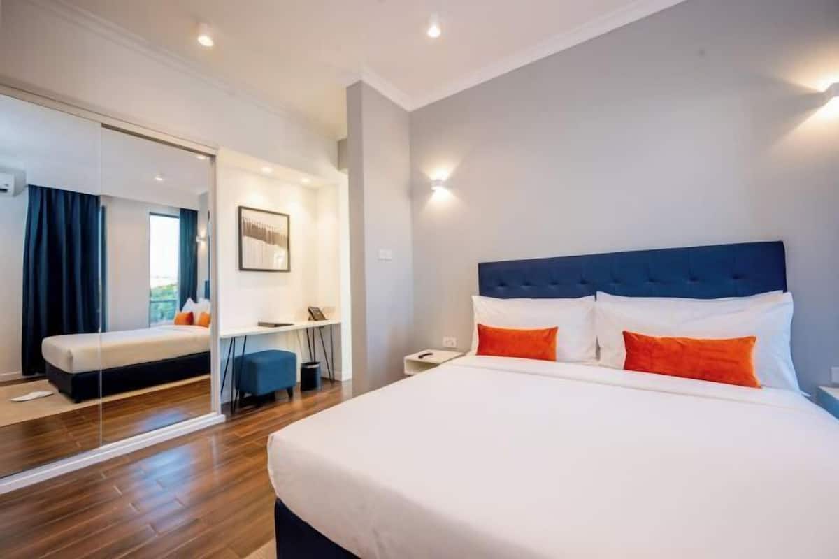 Ein modernes Hotelzimmer mit einem großen Bett, einem Schreibtisch und einem Spiegel.