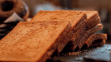 A stack of brown bread slices on a metal surface.