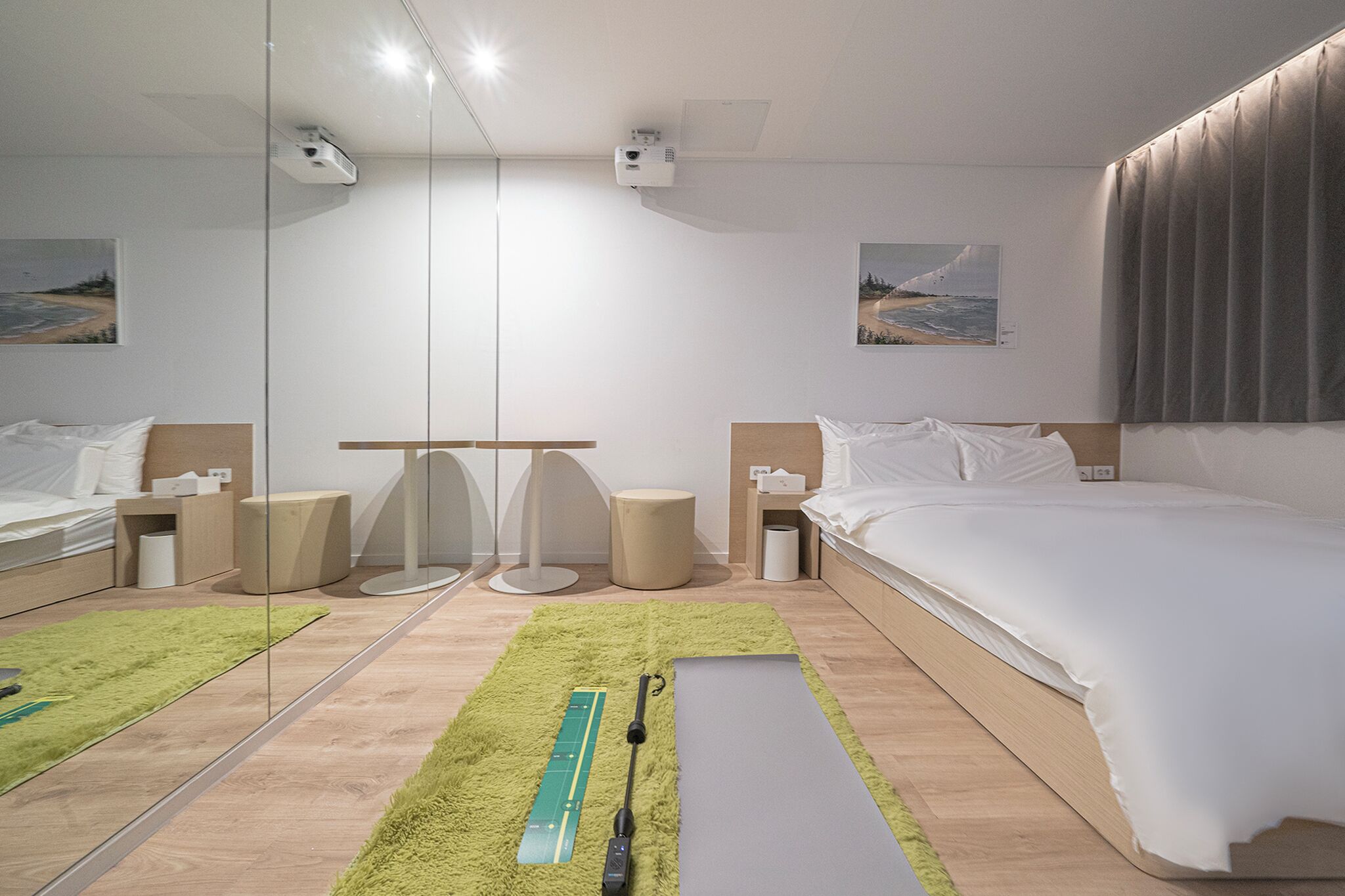 A modern hotel room with a large bed, a desk, and a mirror.