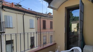 Un balcon équipé d’une table, de chaises et d’un distributeur d’eau.