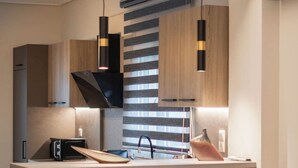 Una cocina moderna con una isla central, luces colgantes y una estufa empotrada.