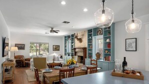 A modern kitchen with a central island, teal cabinetry, and a deer head mounted on the wall. - Revins Haus - Fire Pit & Walk to Main St (Fredericksburg)