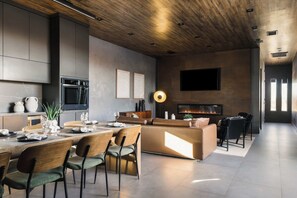 Una cocina moderna con horno empotrado y comedor con mesa redonda y sillas.