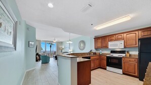 Una cocina amplia con armarios de madera, una isla central, un microondas y una estufa.