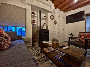 A cozy living room with a sofa, a coffee table, and a fireplace. - Tinguaton 1 (Aldeanueva de Barbarroya)
