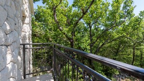A stone wall adjacent to a metal railing overlooking a forested area. - Private villa Iko with swimming pool and view on mountain Biokovo (Zadvarje)