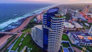 A high-rise hotel with multiple balconies, a beach view, and a coastal location.