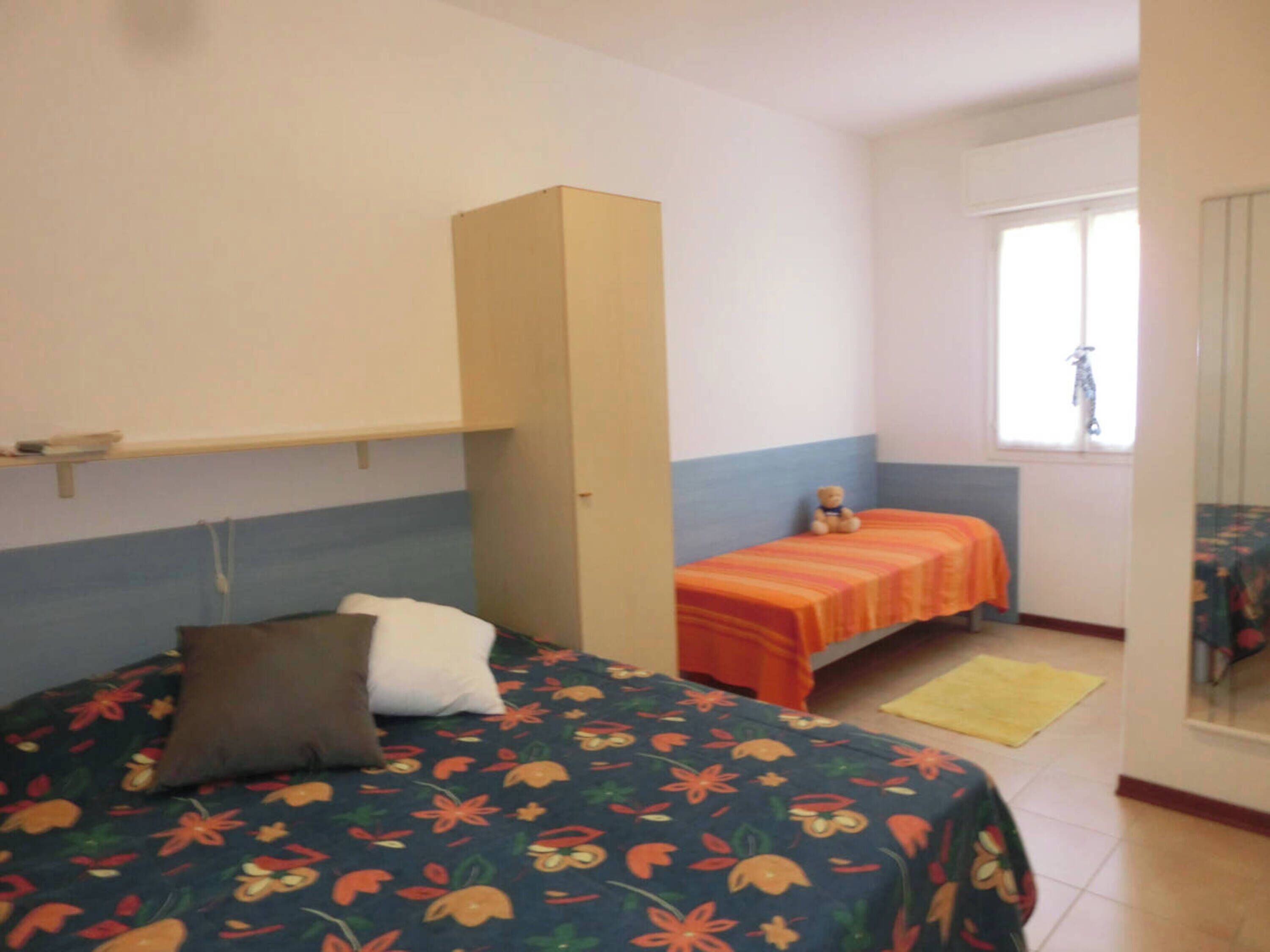 Una stanza piccola e modesta con un letto, un tavolino e una finestra.