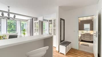A modern kitchen with a white countertop, a built-in sink, and a large window with blinds.