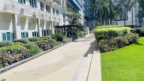 A modern building with multiple balconies, a well-maintained lawn, and a clear pathway. - 2BR Poolview  for 6-10 pax at Sea Residences Mall of Asia 402403 (Pasay)
