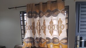 Un soggiorno con un divano, una tenda a motivi geometrici e una porta dal design a griglia.
