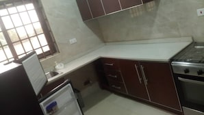 Una cucina compatta con frigorifero, fornelli e pensili.