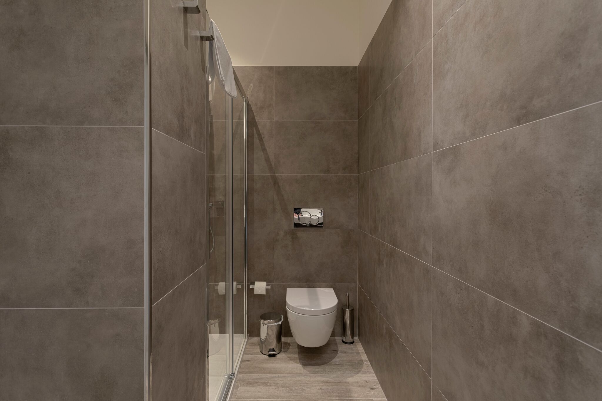 Une salle de bain moderne équipée de toilettes, d’un bidet et d’une douche à parois de verre.