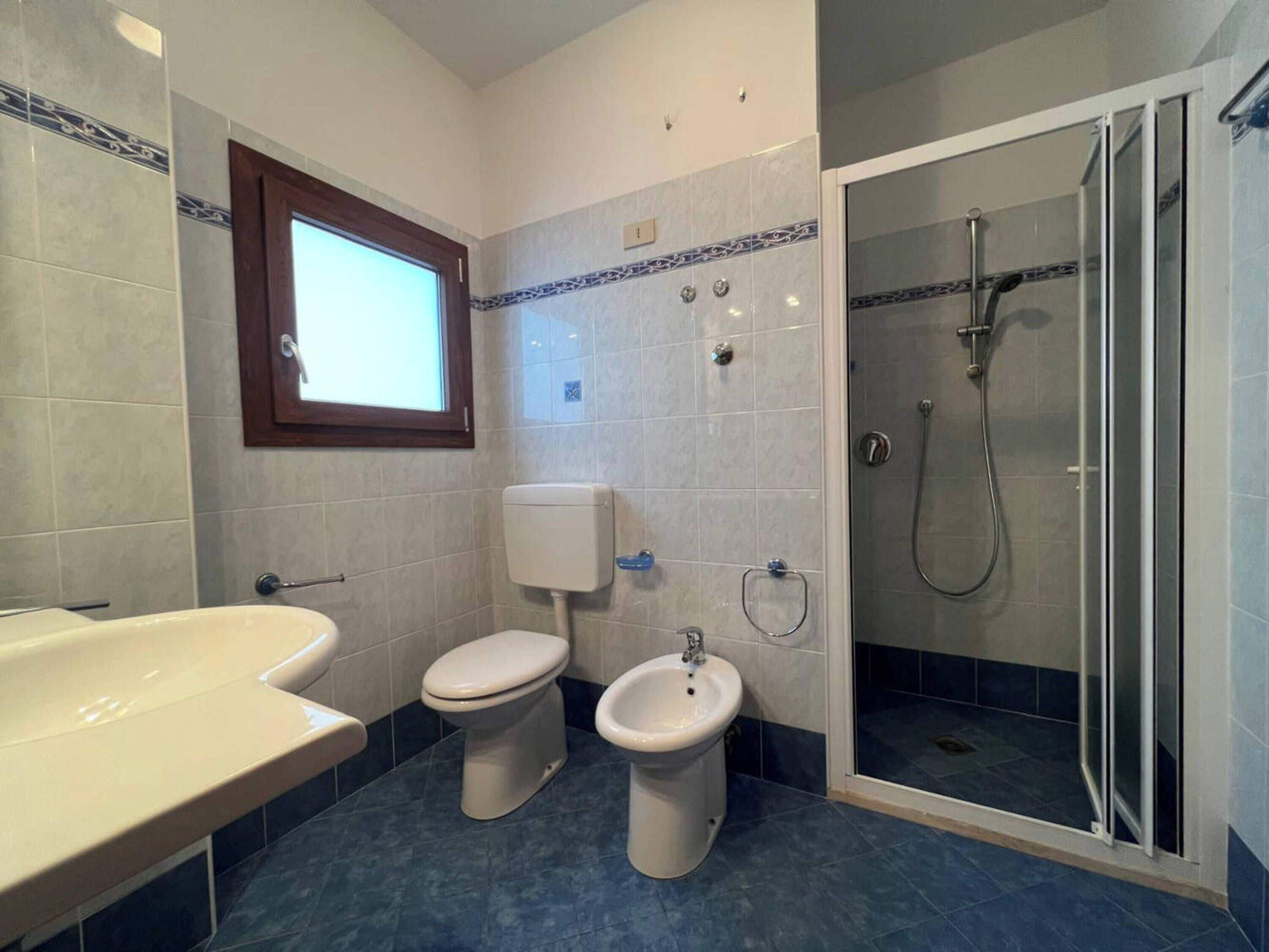 Un baño con bañera, inodoro, bidé y cabina de ducha.