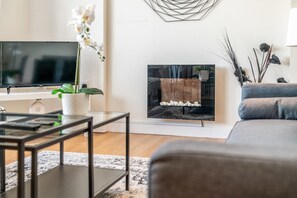 Appartement de base, Plusieurs lits | Aire de séjour | Téléviseur