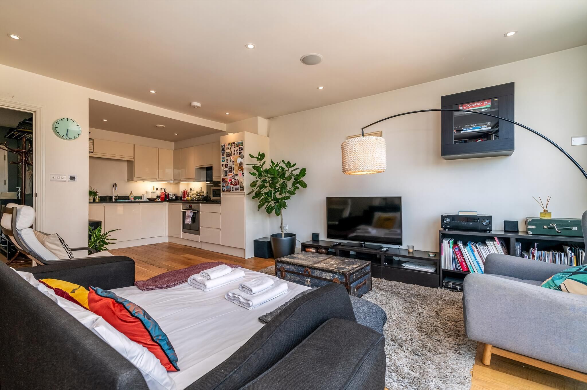 A modern living room with a sofa, a coffee table, a TV, and a bookshelf.