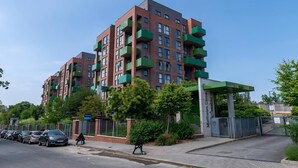 Un immeuble résidentiel à plusieurs étages, doté de balcons, d’une entrée sécurisée et d’un espace de stationnement.