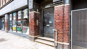 A building with a black door labeled '145' and a sign for 'AstonMalthews bathrooms' on the left. - Contemporary Open Plan Penthouse (London)