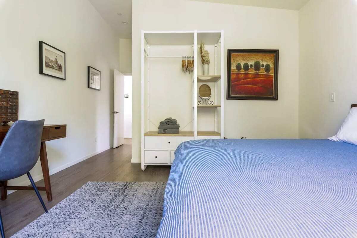 Un dormitorio con cama, escritorio y armario.
