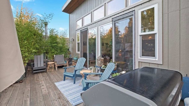 A deck with outdoor seating, a grill, and a view of a house with large windows. - Somms Rest ⎮ Designed. Curated. Peaceful. (Forestville)