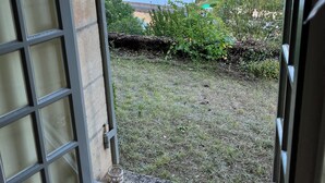 Una porta aperta con vista su un fiume, vegetazione e colline.
