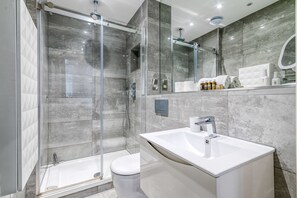 Apartamento básico, várias camas | Banheiro | Toalhas de banho, sabonete, shampoo, papel higiênico