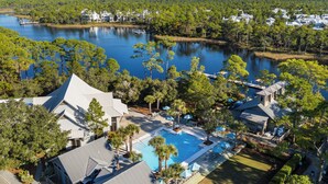 Ein Resort mit großem Schwimmbad, mehreren Gebäuden und einem See im Hintergrund.