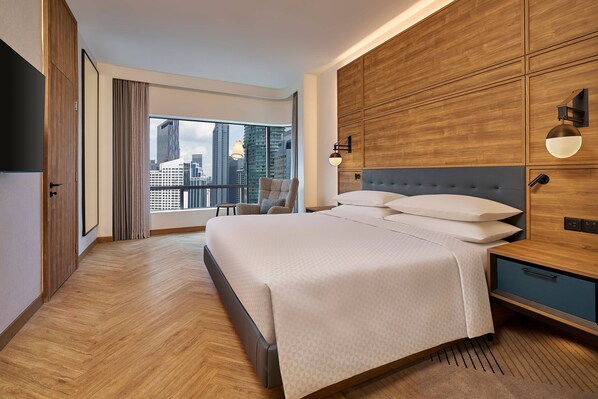 Une chambre d’hôtel moderne avec un grand lit, une vue sur la ville et un mur décoratif en bois.