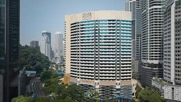 A high-rise hotel with a distinctive curved facade, multiple balconies, and a prominent signage.