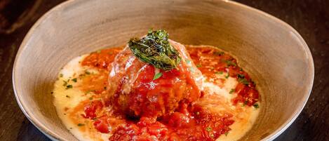 A dish with a sauce and a garnish on a plate.